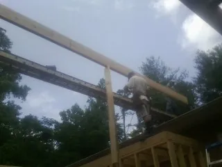 Carpenter setting a ridge beam over a new addition frame — Ice Dam Removal by Roofing Brothers in Beatty