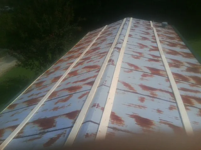 Rusted metal roof panels with new wood purlins before replacement — Storm Damage Roof Repair in Beatty by Roofing Brothers