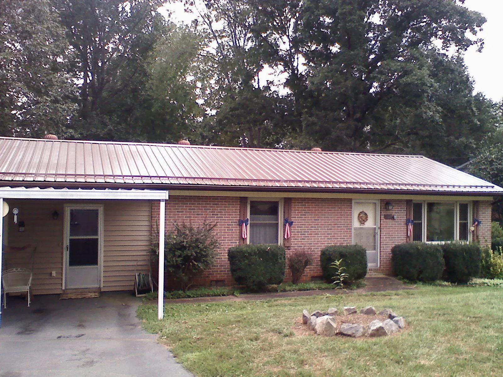 Bronze metal roof and carport on a brick ranch home — Roof Repair work by our crew in Beatty